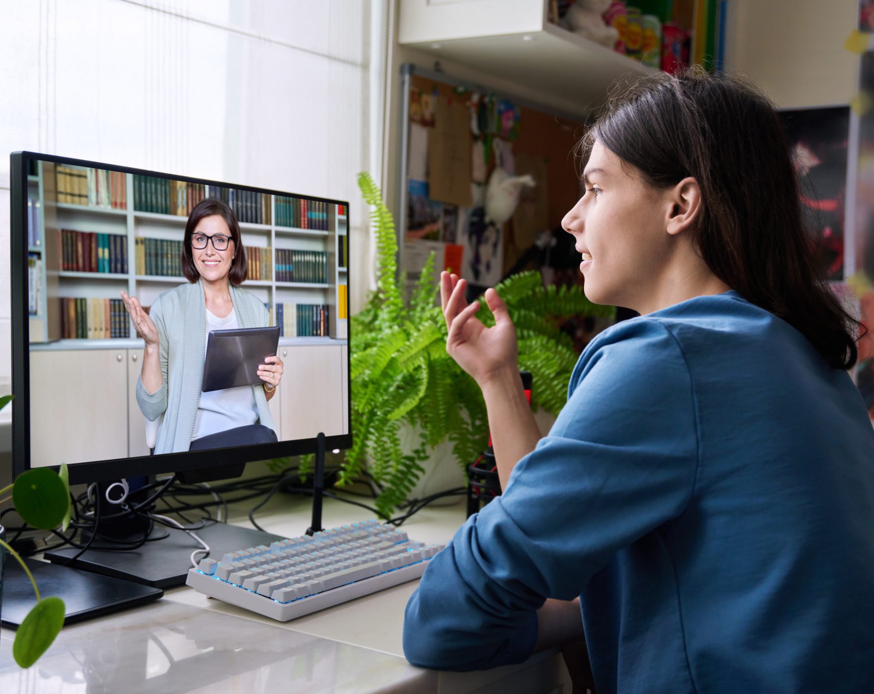 Student video calling tutor at desk
