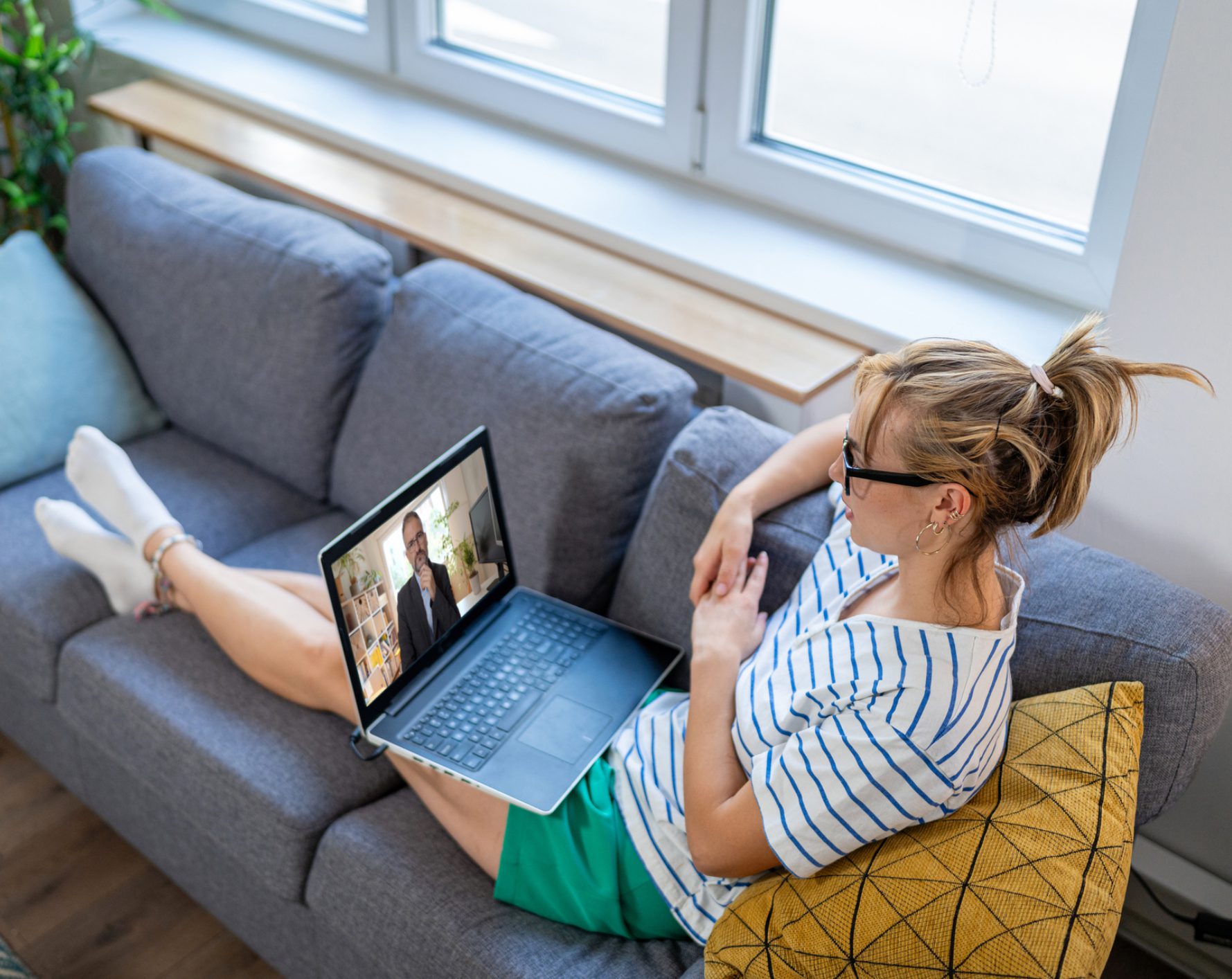 Woman lounging on couch video calling