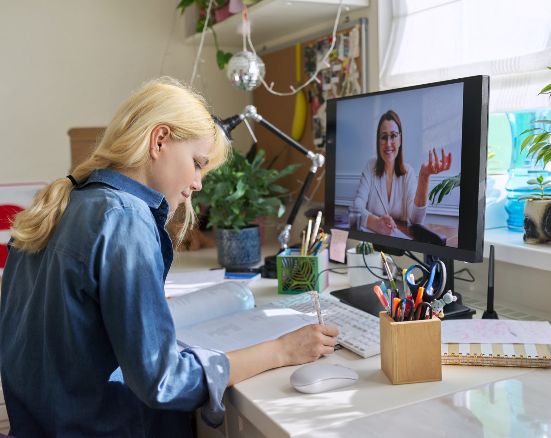 Student studying at desk during video lesson