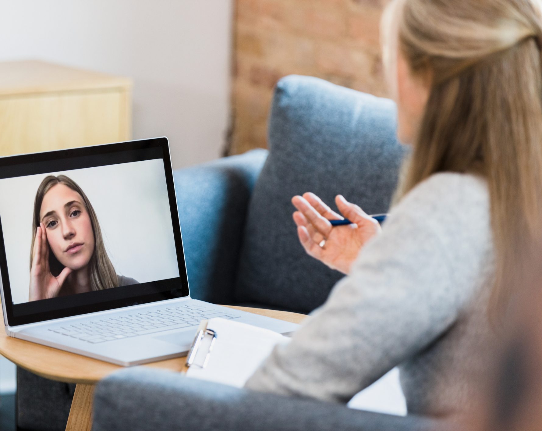 Therapist conducting virtual therapy session on laptop