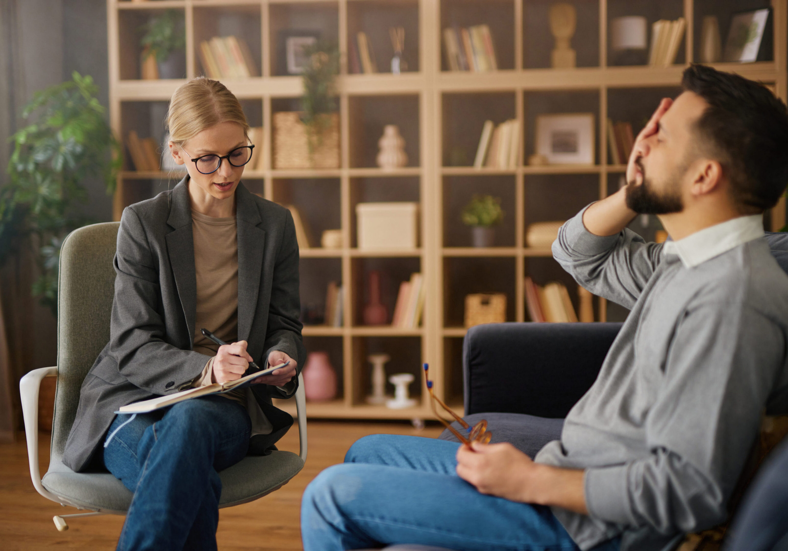 Therapist listens to man during counseling session.